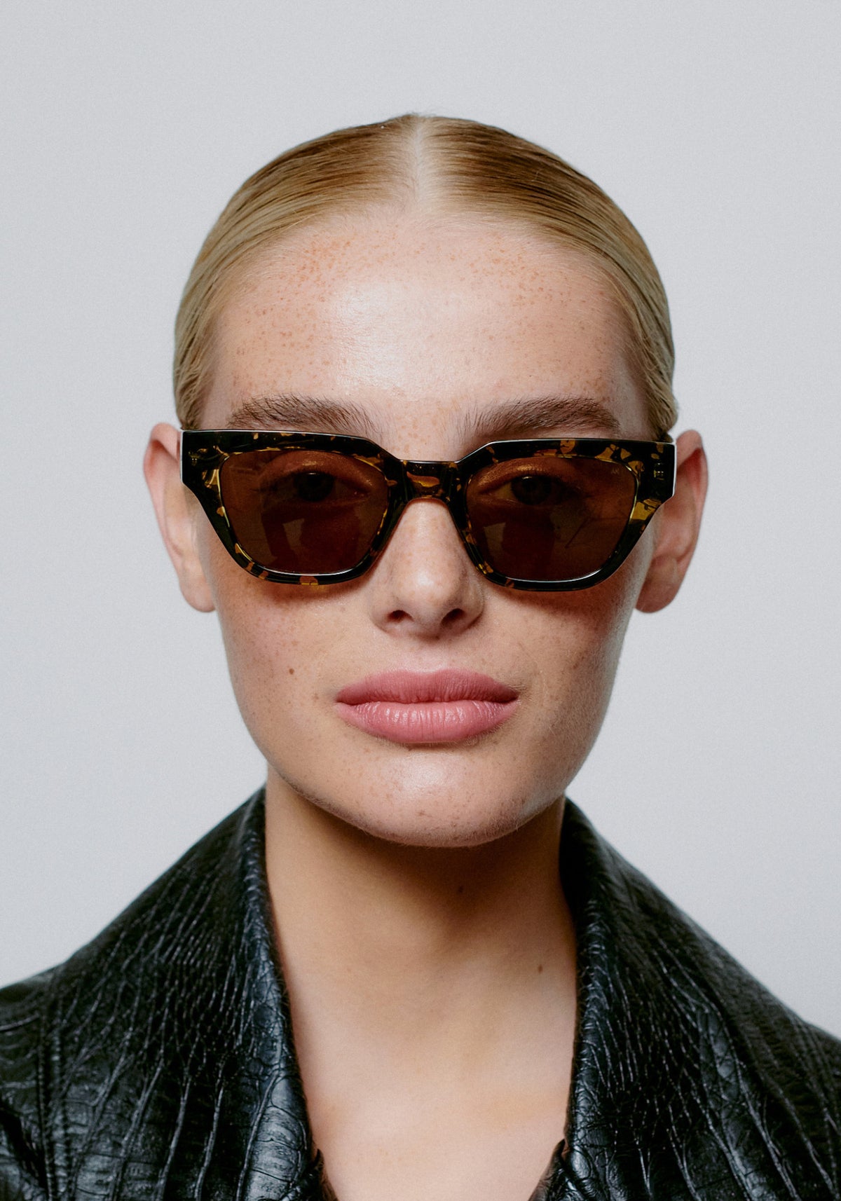 La femme porte les lunettes de soleil Kaws black yellow tortoise de chez A.Kjaerbede