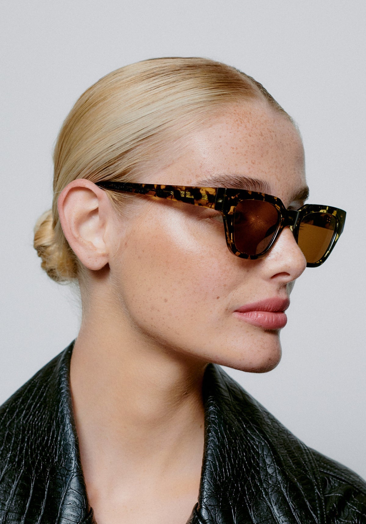 La femme porte les lunettes de soleil Kaws black yellow tortoise de chez A.Kjaerbede