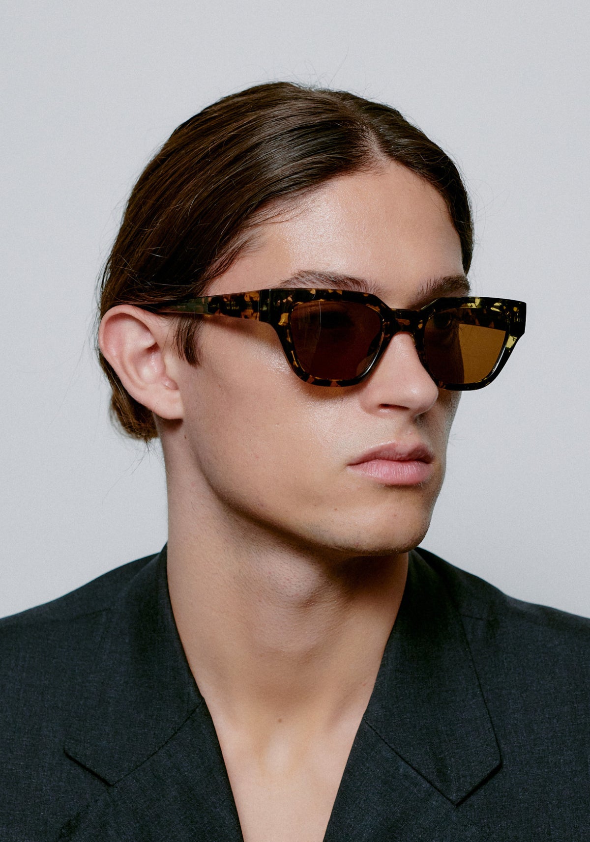 L'homme porte les lunettes de soleil Kaws black yellow tortoise de chez A.Kjaerbede
