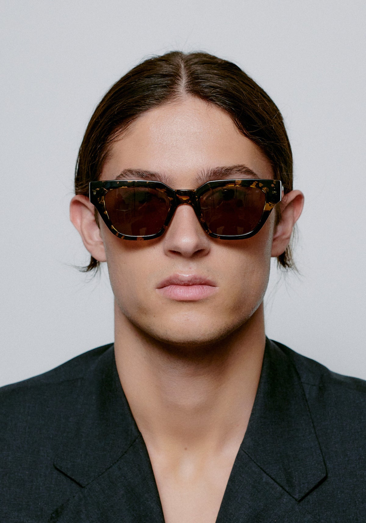 L'homme porte les lunettes de soleil Kaws black yellow tortoise de chez A.Kjaerbede