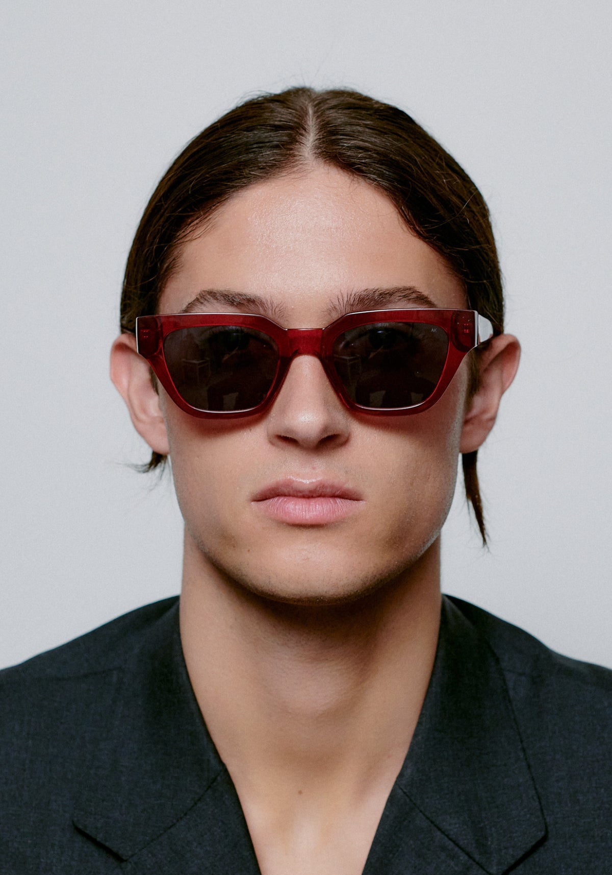 L'homme porte les lunettes Kaws burgundy transparent de chez A.Kjaerbede