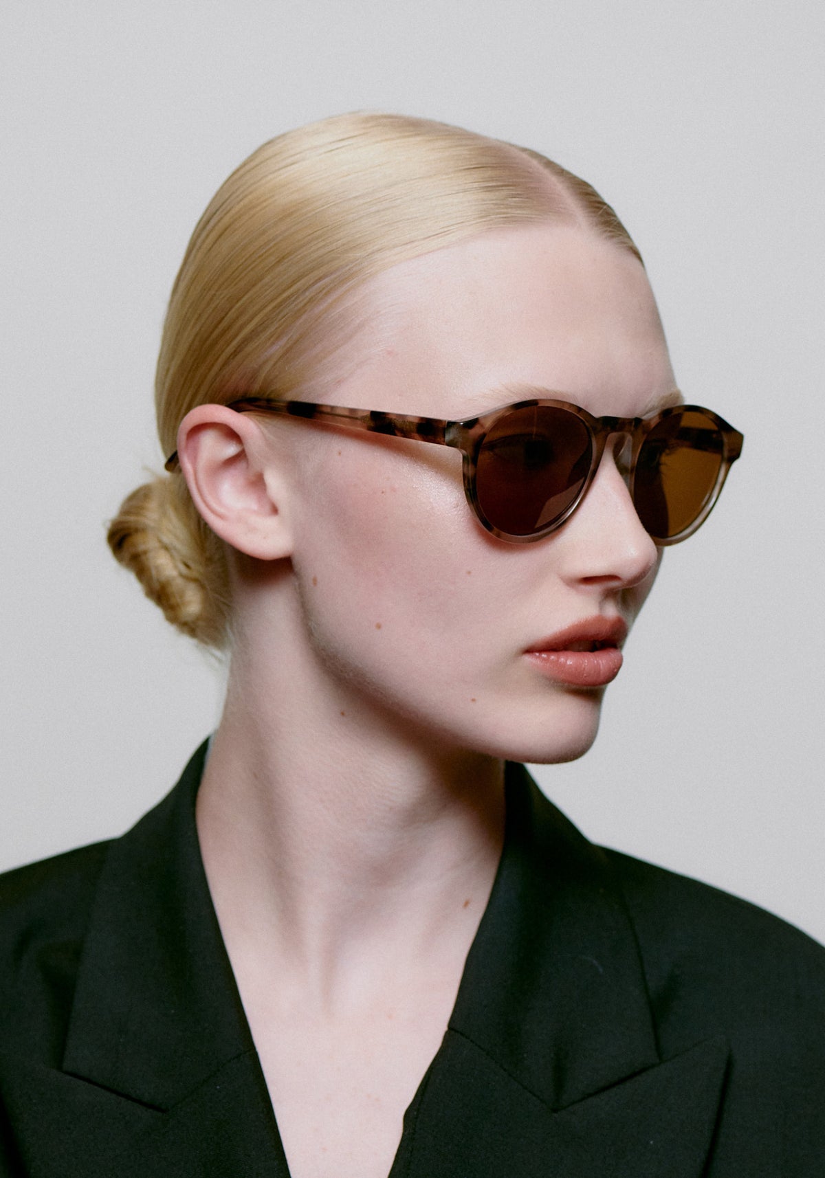 La femme porte les lunettes de soleil Marvin coquina de chez A.Kjaerbede