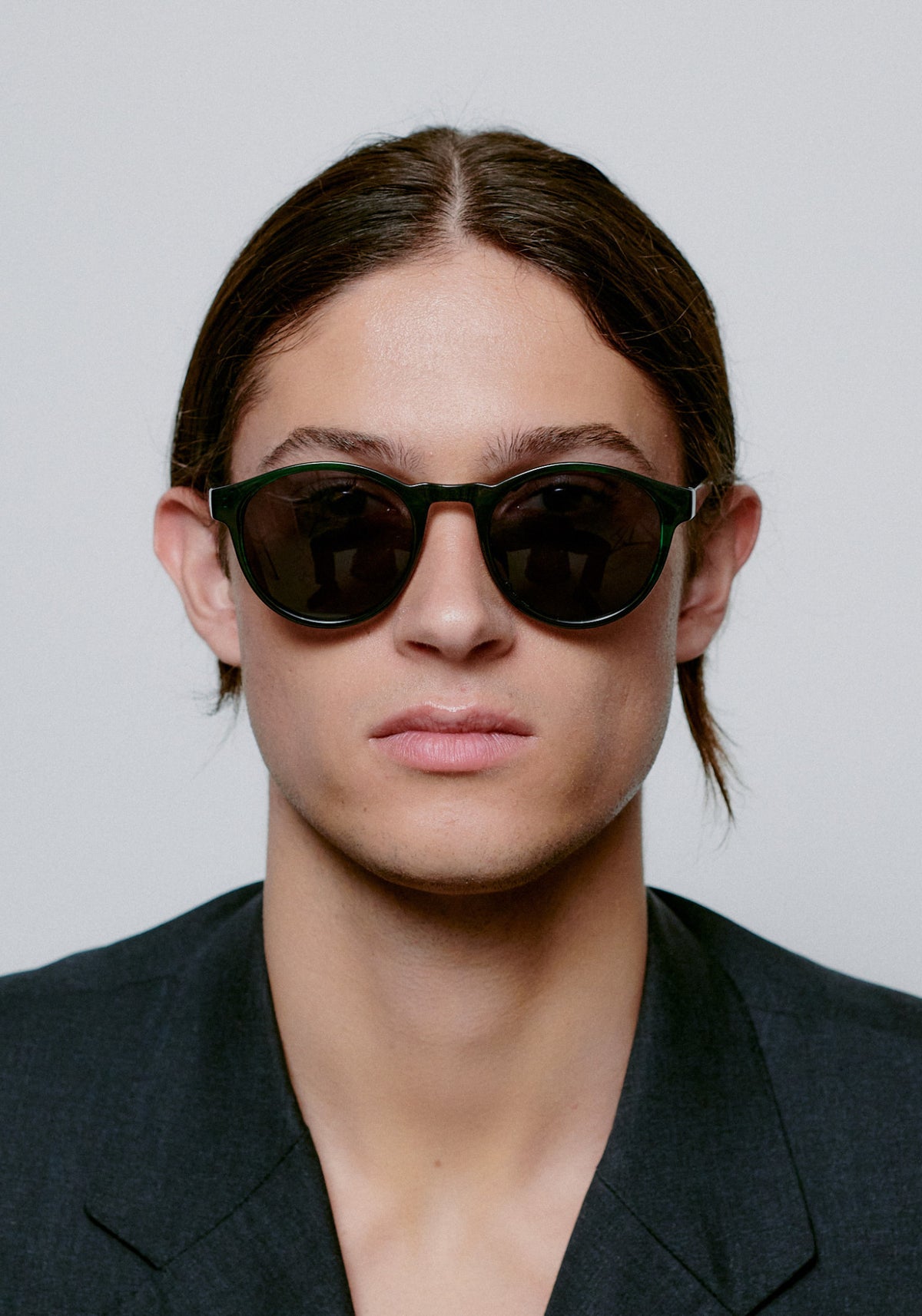 L'homme porte les lunettes de soleil Marvin green marbre transparent de chez A.Kjaerbede