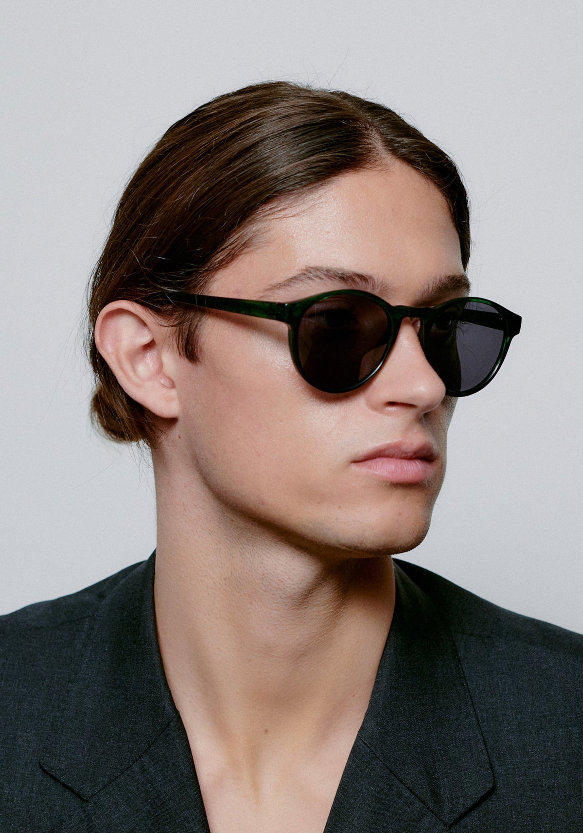L'homme porte les lunettes de soleil Marvin green marbre transparent de chez A.Kjaerbede