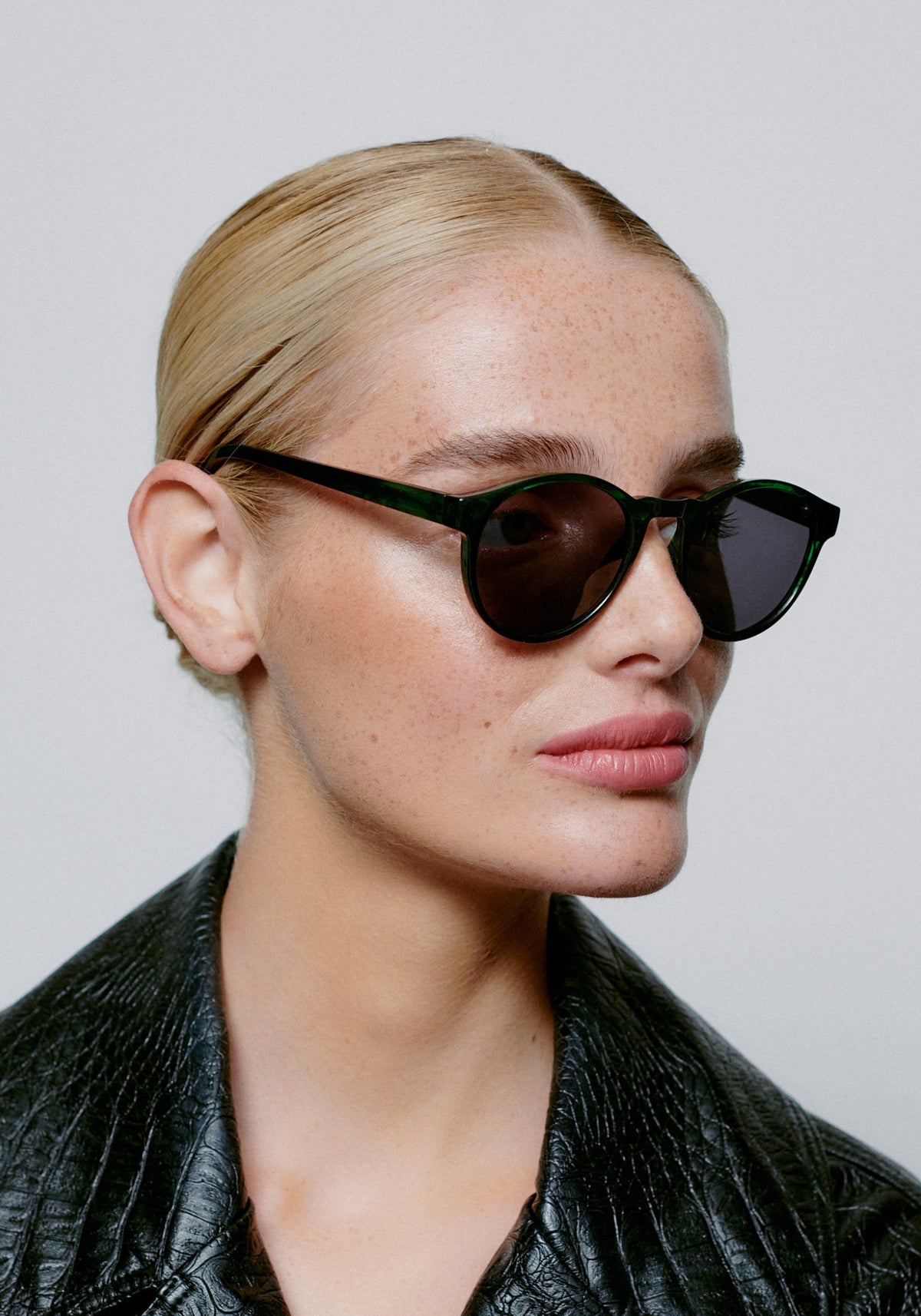 La femme porte les lunettes de soleil Marvin green marbre transparent de chez A.Kjaerbede