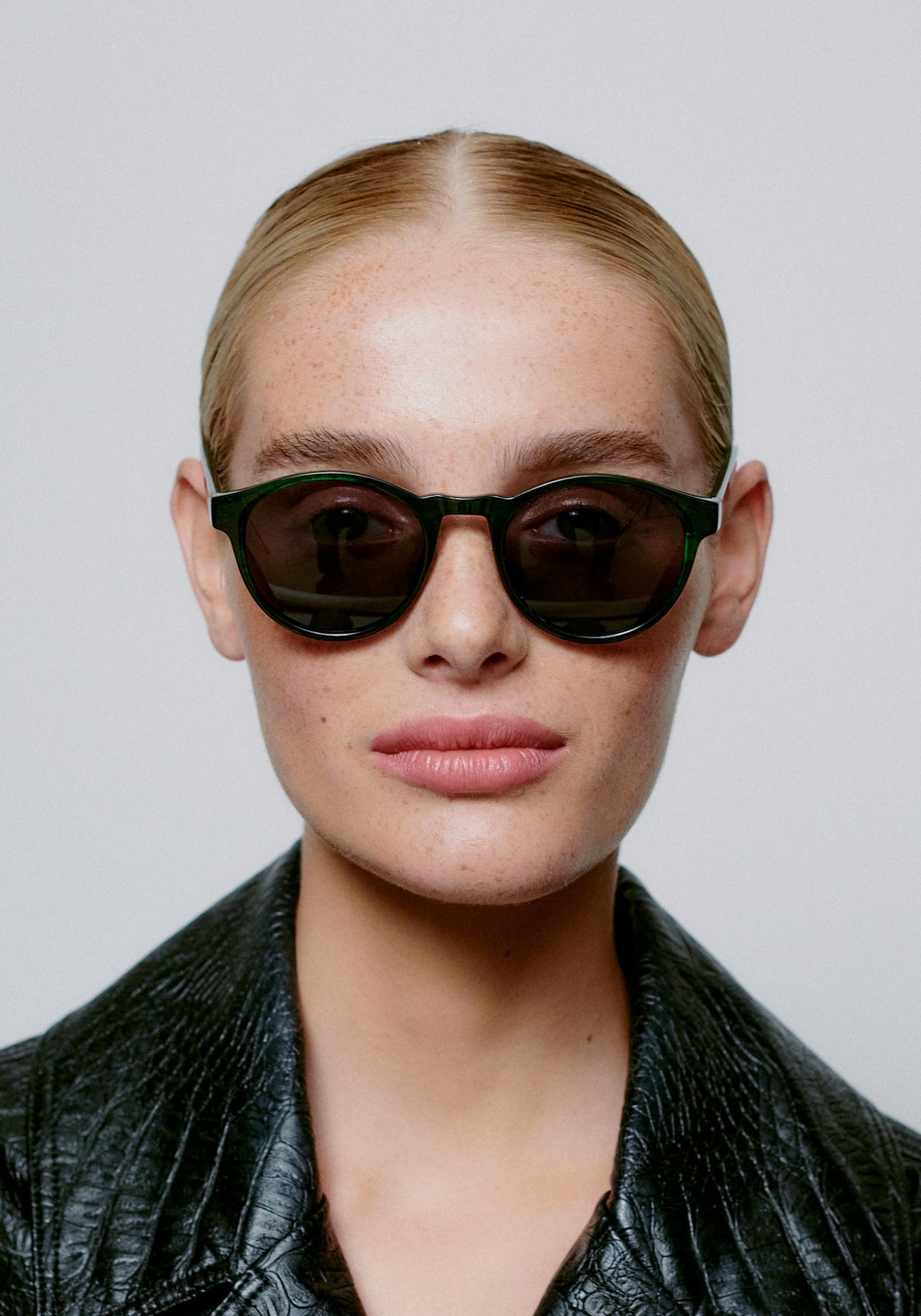 La femme porte les lunettes de soleil Marvin green marbre transparent de chez A.Kjaerbede