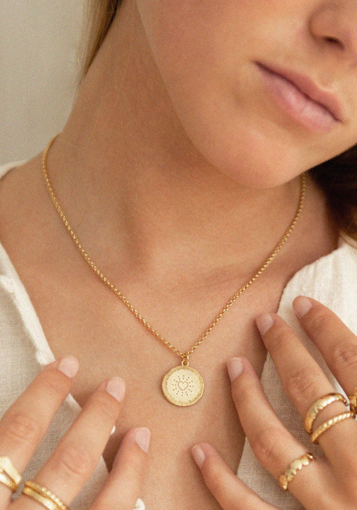 La femme porte la médaille Amante de chez Bacci Paris