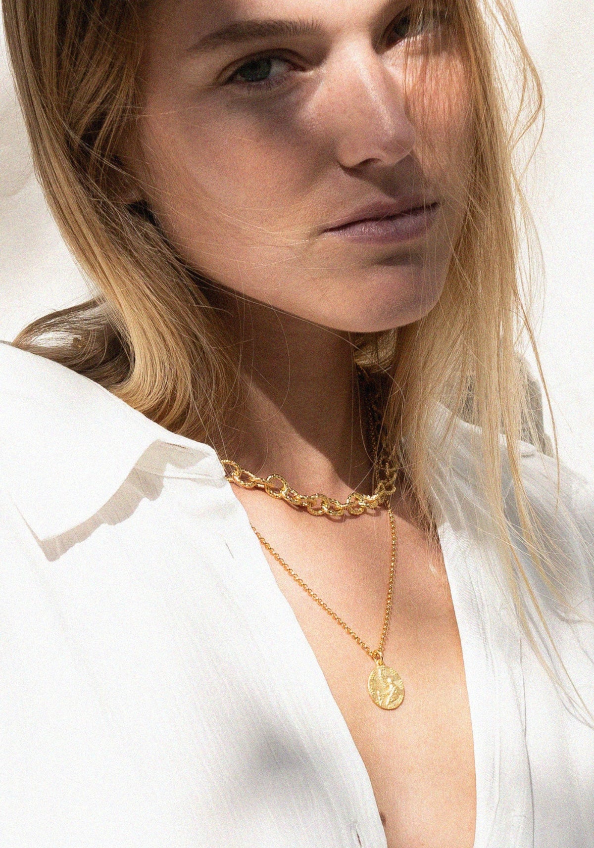La femme porte la médaille Gratia de chez Bacci Paris