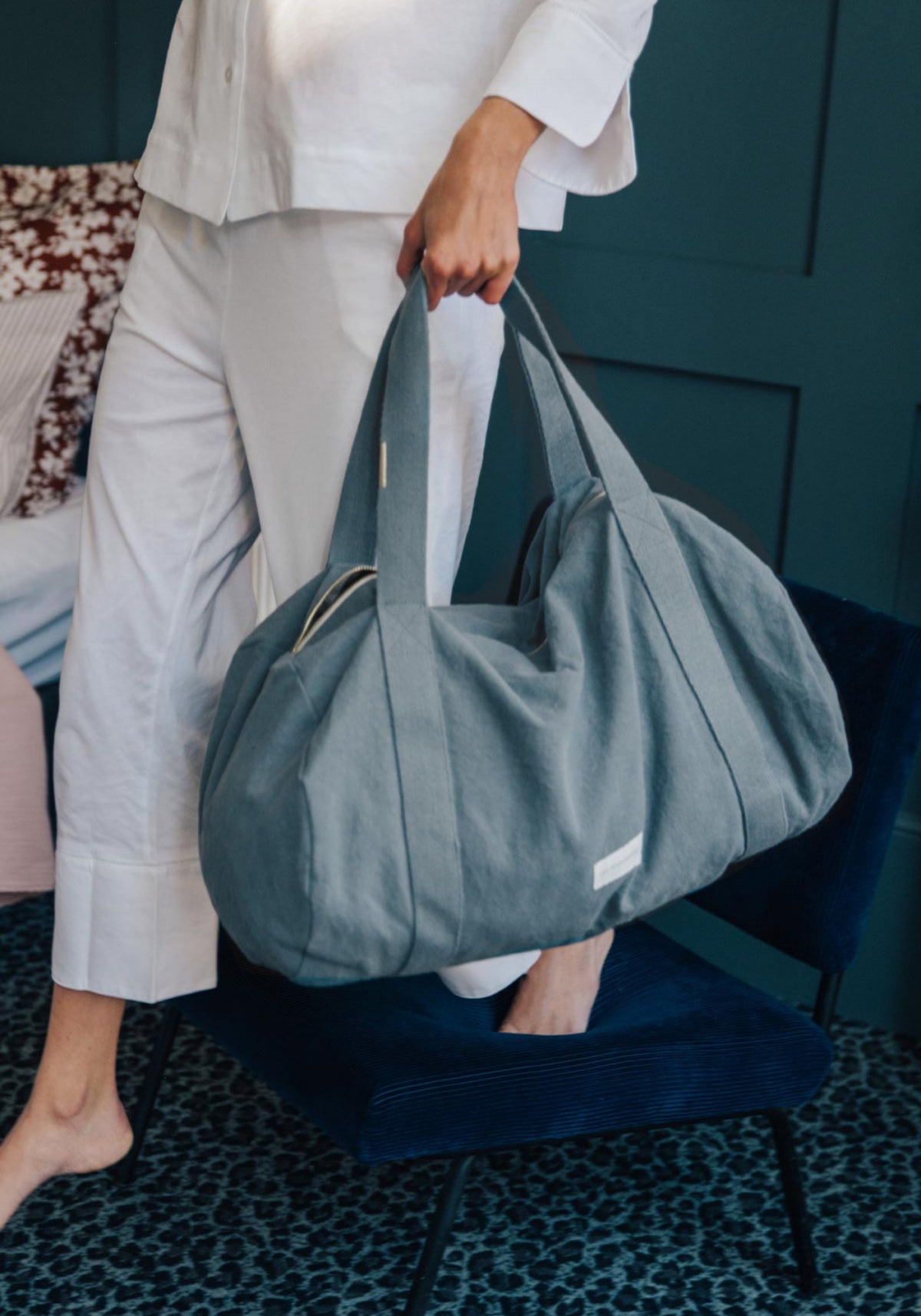 La femme porte le sac bowling bleu horizon de chez Les Pensionnaires