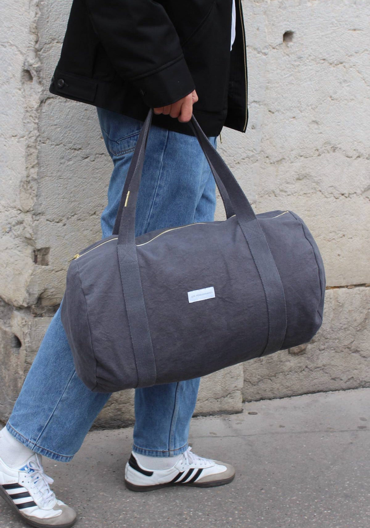 L'homme porte le sac bowling gris ardoise de chez Les Pensionnaires