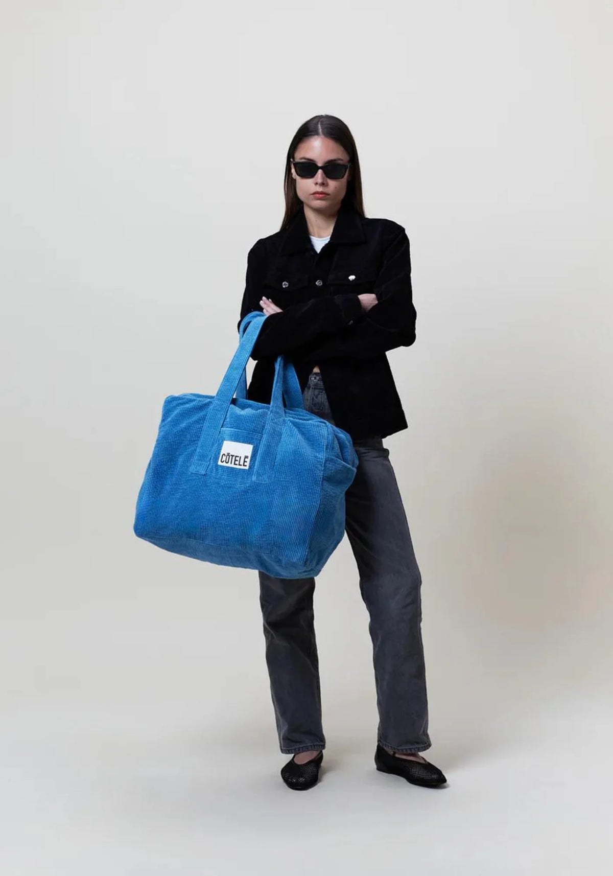 La femme porte à son bras le sac en velours week-end Bonny Sifnos de chez Côtelé Paris