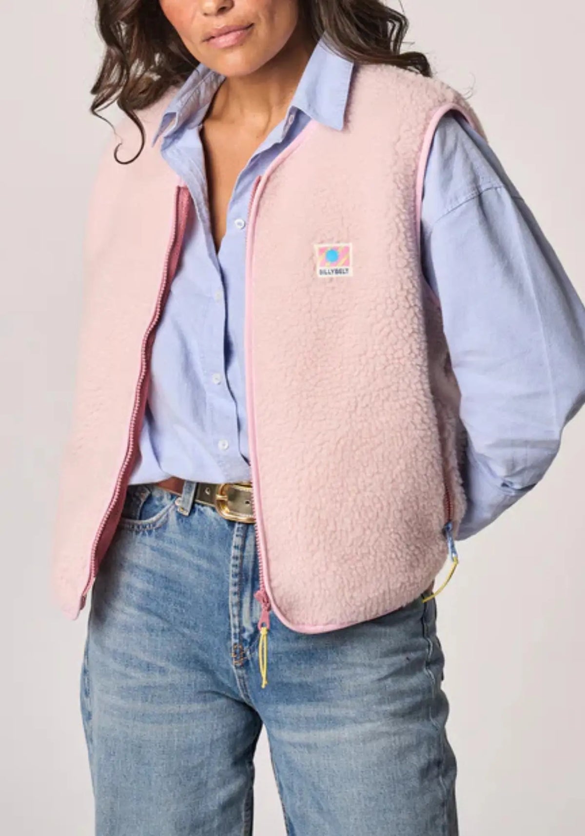 La femme porte la sherpa mixte zippée sans manches rose pâle de chez Billybelt