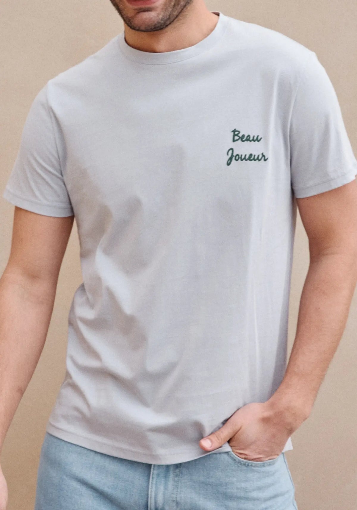 L'homme porte le t-shirt MC beau bleu gris de chez Jaqk 