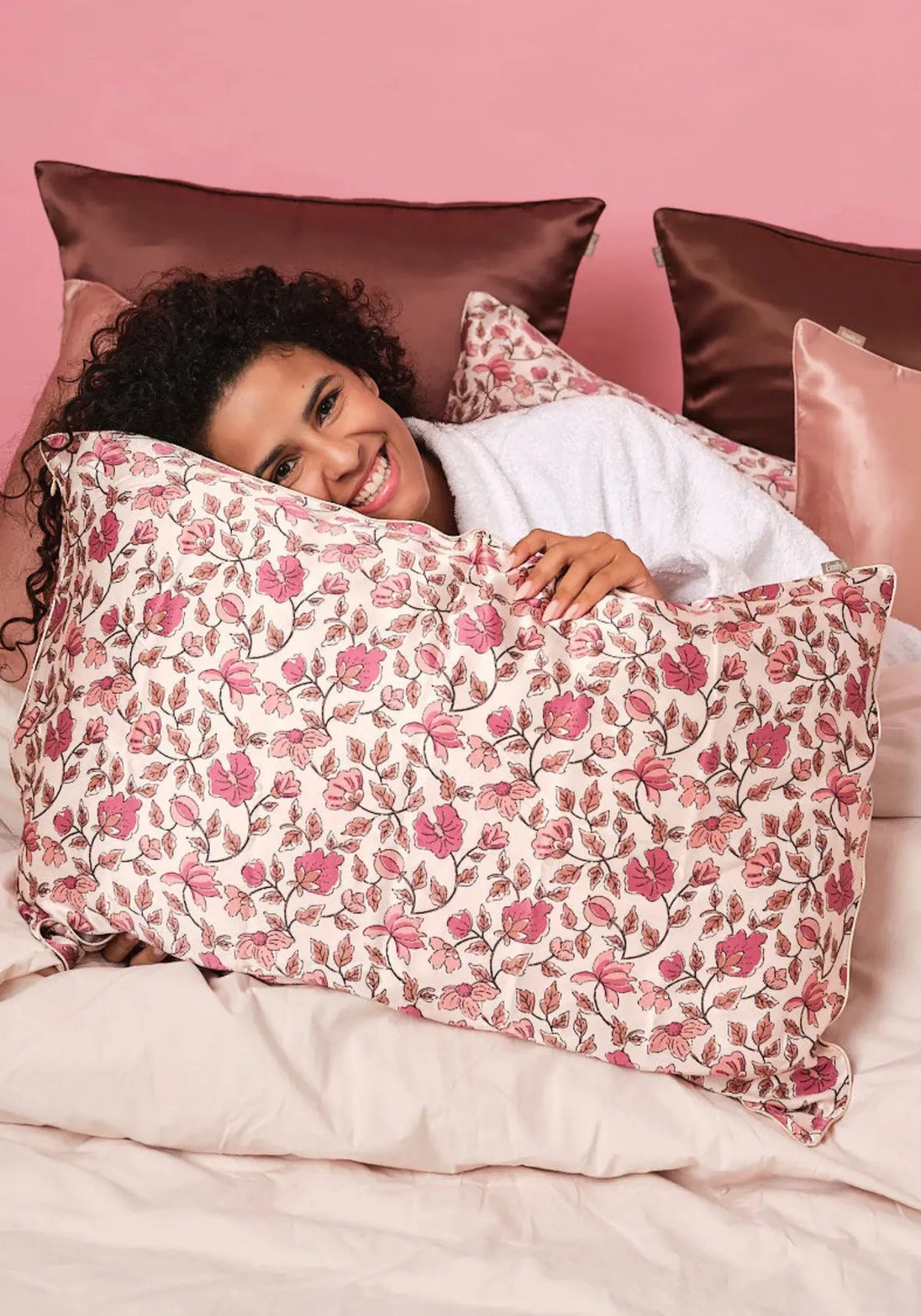 La femme est allongé sur la taie d'oreiller en soie rectangle fleurs d'automne de chez Emily's Pillow