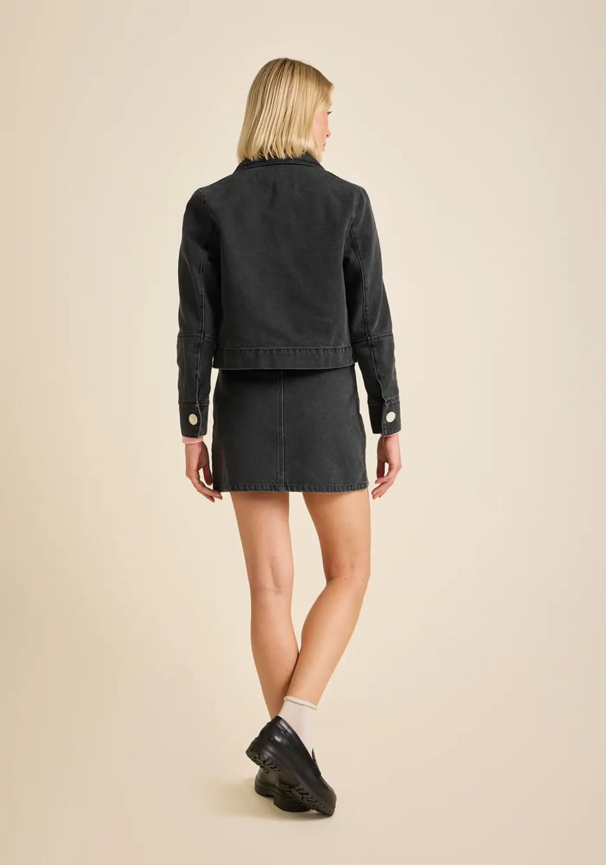 La femme porte la veste courte en velours daisy coloris jean anthracite de chez Côtelé Paris 