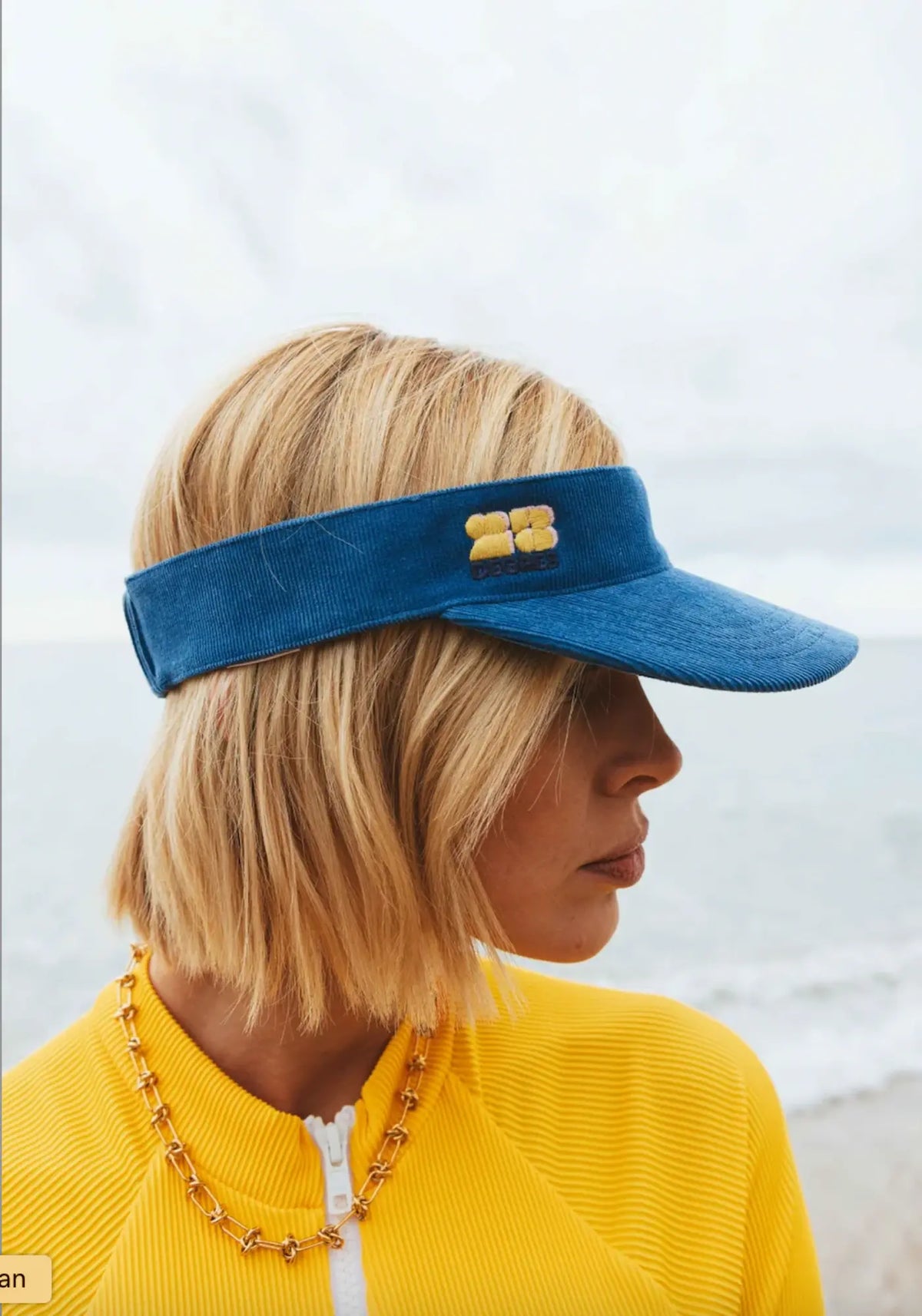 La femme porte la visière sunset bleu de chez 23 Degrés
