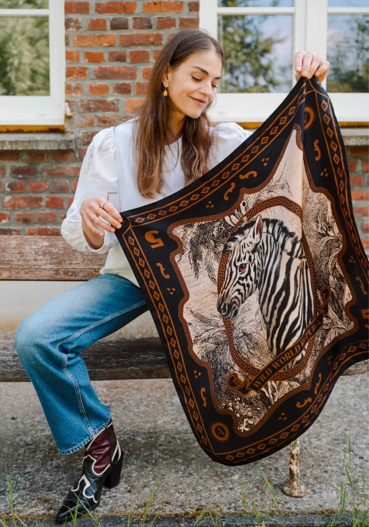 La femme porte le foulard wwr silk 70 zebra de chez Antan Créations