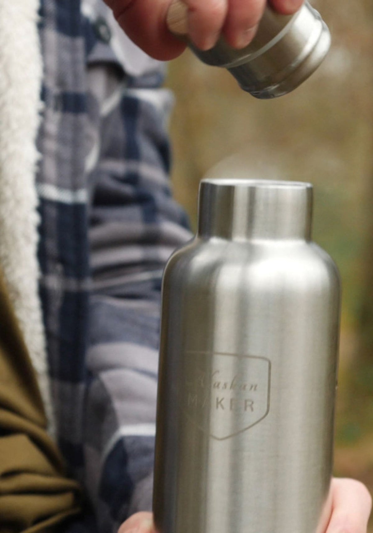 L'homme ouvre la gourde River en inox de chez Alaskan Maker