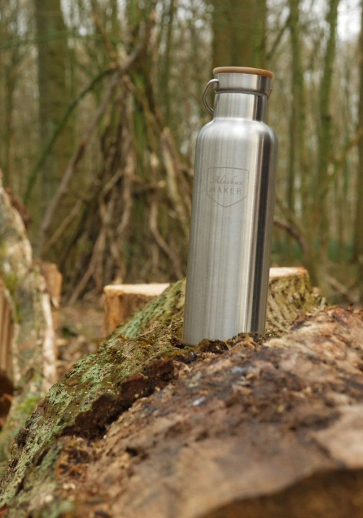 La gourde thermos River de chez Alaskan Maker est posée sur un rocher dans la forêt